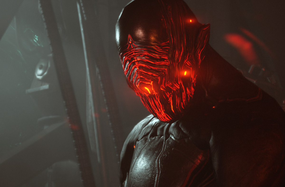 A being with black armour and a glowing red face against a dark sci fi background