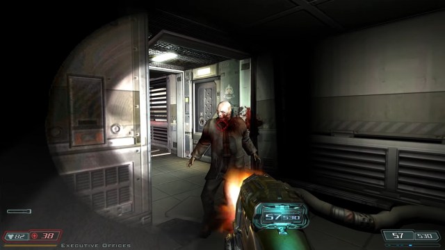 Doom 3: Der Spieler schießt auf einen Zombie, der durch eine Tür gekommen ist.