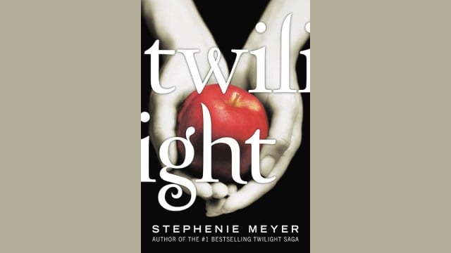 The cover of Twilight; a pair of pale hands holding an apple.