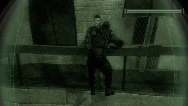 Splinter Cell Chaos climbs over a railing in the dark as an enemy looks on unaware.