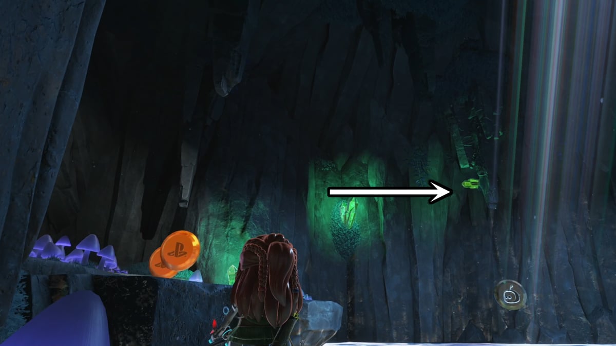 Aloy in a cavern with an arrow pointing to a bot's location.