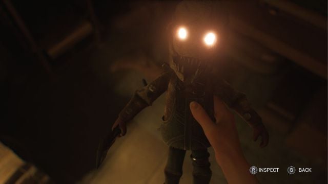 Madi holding a doll with glowing eyes resembling the Trapper.