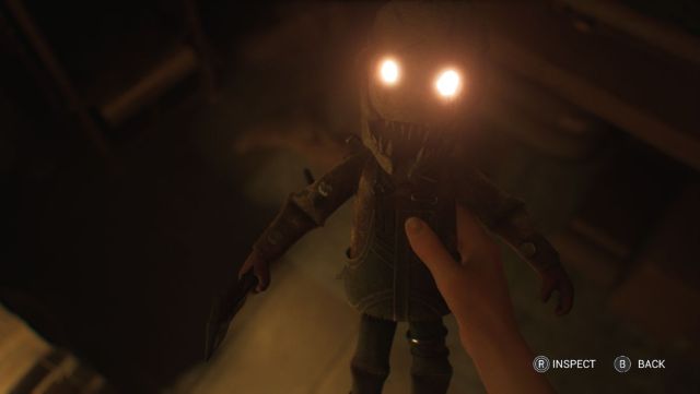 Madi holding a doll with glowing eyes resembling the Trapper.