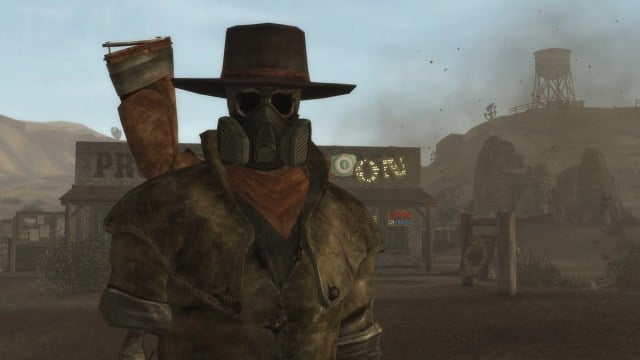 Fallout New Vegas: a stranger wearing a brimmed hat looks menacing in the Mojave Desert.