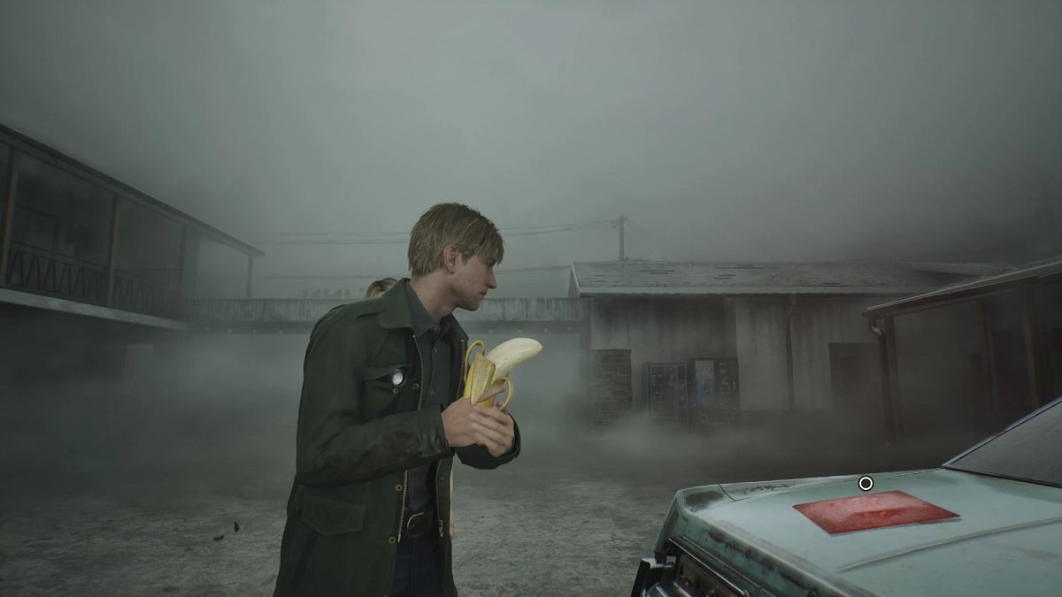 Silent Hill 2: James Sunderland holds a banana like a gun while he stares at something on the trunk of a car.