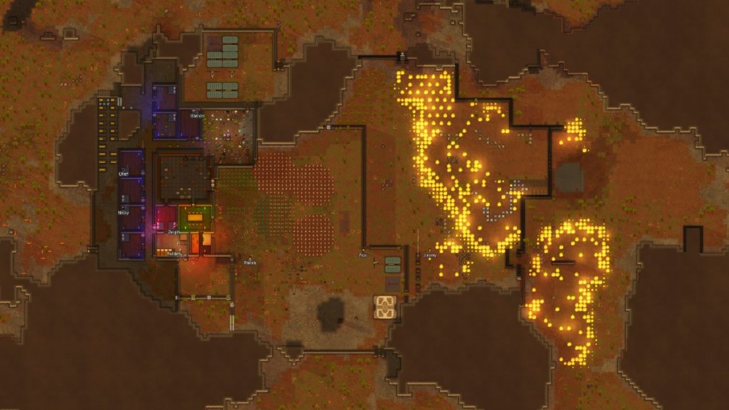 A large view from above of a player base, half of it is on fire.